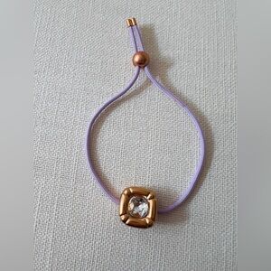 Swarovski Dulcis bracelet with a purple braided cord and a rose gold-tone plated